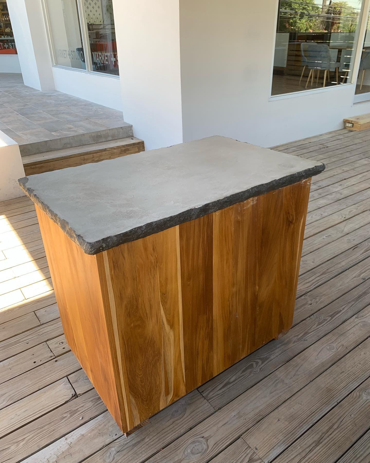 A straight working surface meets an irregular live edge, above the timber cabinet.