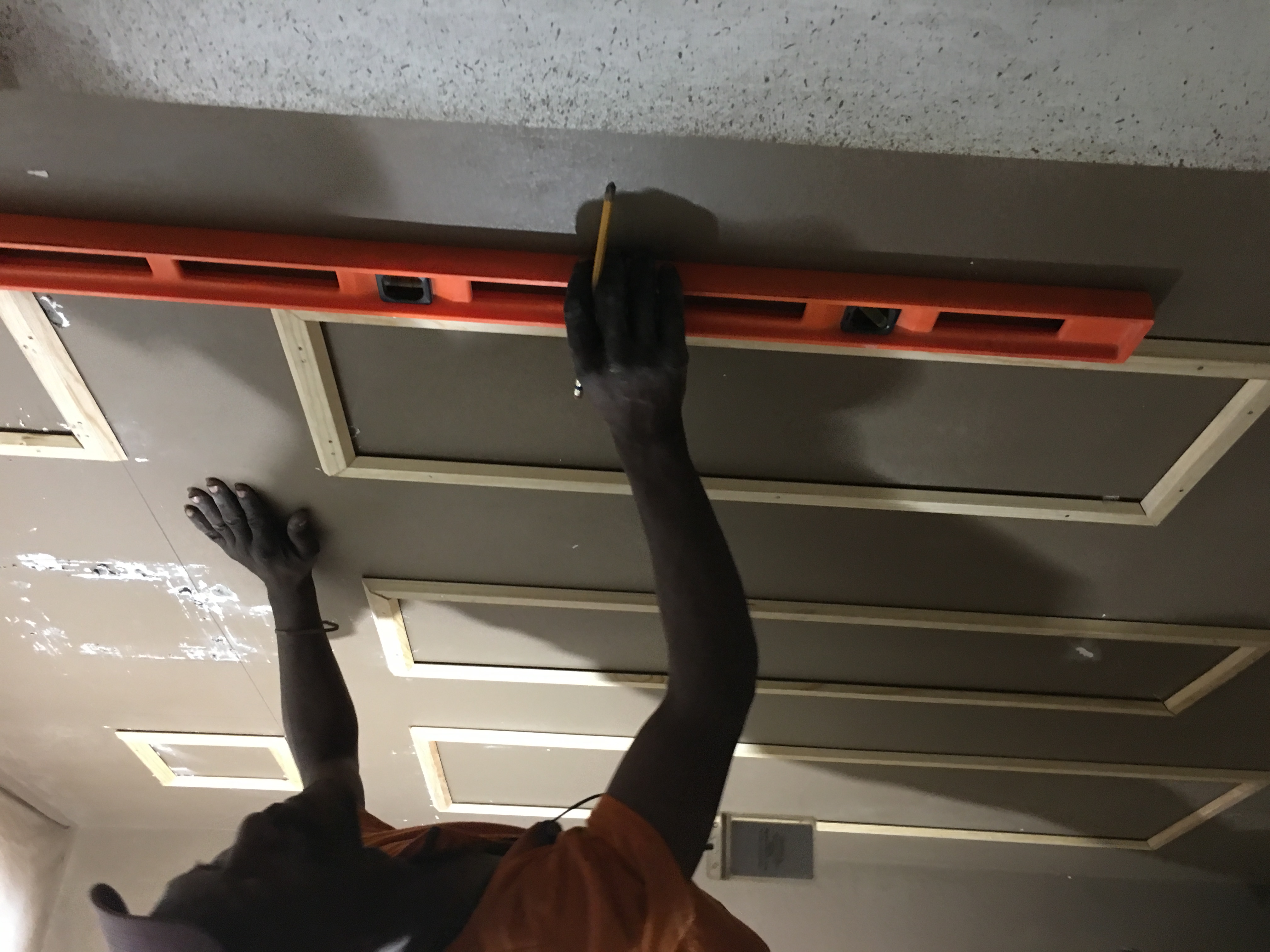 Checking the vertical alignment of the powder-room panels with a spirit level during installation